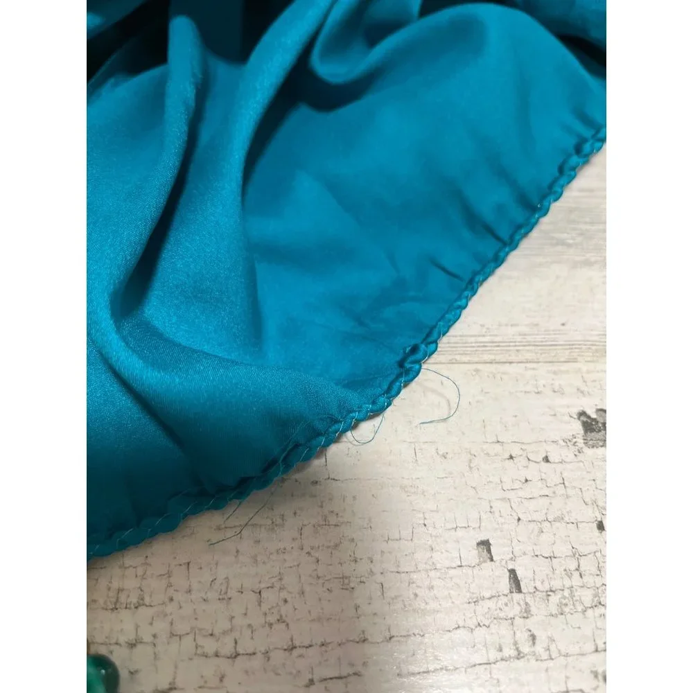 Teal colored shawl wrap with teal, silver, and gold beads on ends
